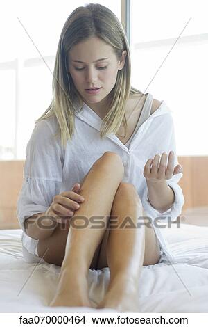 Woman moisturizing legs View Large Photo Image Picture - Woman moisturizing legs. Fotosearch