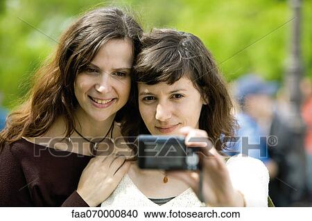 Woman photographing herself with friend View Large Photo Image Stock Image - Woman photographing herself with friend. Fotosearch
