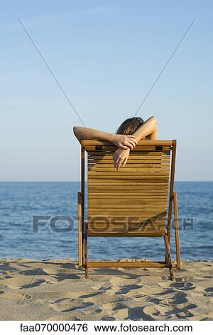 Woman relaxing in lounge chair on beach View Large Photo Image Stock Photograph - Woman relaxing in lounge chair on beach. Fotosearch