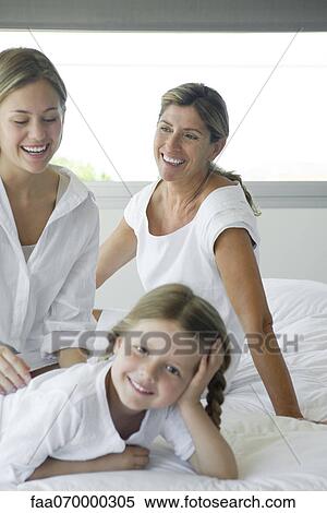 Woman relaxing on bed with daughter and granddaughter View Large Photo Image Stock Photography - Woman relaxing on bed with daughter and granddaughter. Fotosearch
