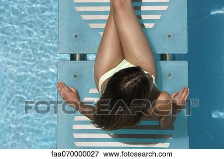 Woman relaxing on swimming pool footbridge View Large Photo Image Stock Photo - Woman relaxing on swimming pool footbridge. Fotosearch