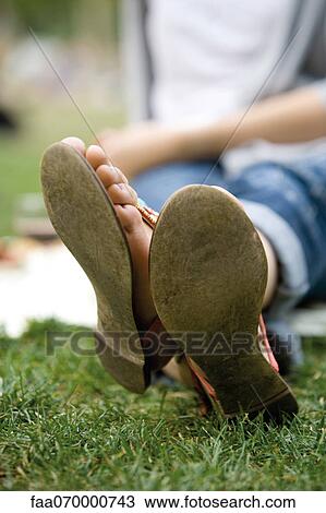 Woman sitting in grass with legs crossed at ankle, cropped View Large Photo Image Stock Image - Woman sitting in grass with legs crossed at ankle, cropped. Fotosearch