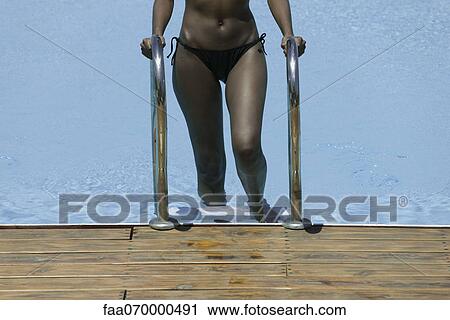 Woman stepping out of swimming pool View Large Photo Image Stock Image - Woman stepping out of swimming pool. Fotosearch