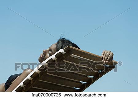 Woman sunbathing on deckchair View Large Photo Image Stock Photograph - Woman sunbathing on deckchair. Fotosearch