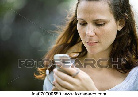 Woman text messaging with cell phone View Large Photo Image Stock Image - Woman text messaging with cell phone. Fotosearch