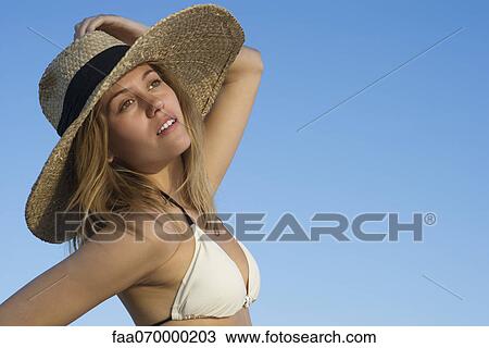 Woman wearing bikini and sun hat looking away dreamily, portrait View Large Photo Image Stock Image - Woman wearing bikini and sun hat looking away dreamily, portrait. Fotosearch