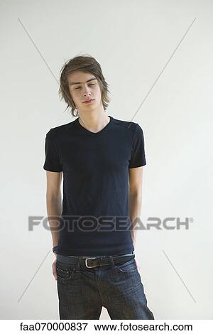 Stock Photo - Young man standing with eyes closed. Fotosearch