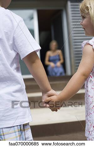 Young siblings holding hands outdoors, rear view View Large Photo Image Stock Photography - Young siblings holding hands outdoors, rear view. Fotosearch