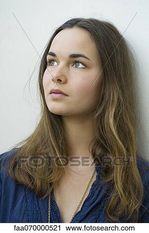 Stock Image - Young woman daydreaming, portrait. Fotosearch
