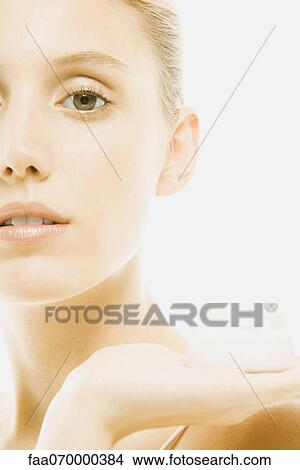 Young woman holding jar of moisturizer, cropped View Large Photo Image Picture - Young woman holding jar of moisturizer, cropped. Fotosearch