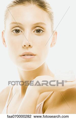 Young woman holding jar of moisturizer, portrait View Large Photo Image Stock Image - Young woman holding jar of moisturizer, portrait. Fotosearch