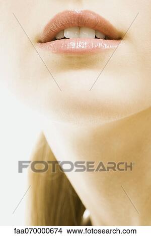 Young woman wearing lip gloss, close-up of face, cropped View Large Photo Image Picture - Young woman wearing lip gloss, close-up of face, cropped. Fotosearch
