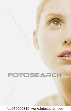 Stock Photo - Young woman with bare shoulders, looking up, cropped. Fotosearch