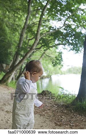Baby girl in woods View Large Photo Image Stock Photo - Baby girl in woods. Fotosearch