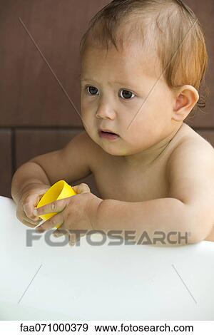 Stock Photo - Baby looking away in thought, portrait. Fotosearch