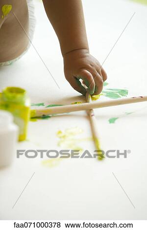 Stock Photo - Baby's hand picking up paintbrush. Fotosearch