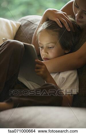 Boy and his mother looking at digital tablet View Large Photo Image Picture - Boy and his mother looking at digital tablet. Fotosearch