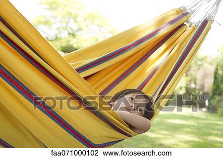 Boy daydreaming in hammock View Large Photo Image Stock Image - Boy daydreaming in hammock. Fotosearch