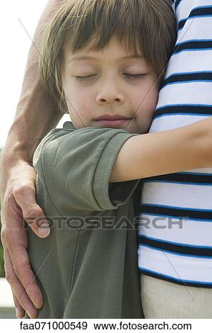 Stock Photo - Boy embracing his father, close-up. Fotosearch