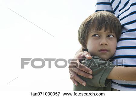 Boy embracing his father, looking away in thought View Large Photo Image Stock Photo - Boy embracing his father, looking away in thought. Fotosearch