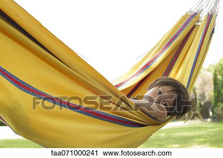 Boy lying in hammock View Large Photo Image Stock Image - Boy lying in hammock. Fotosearch