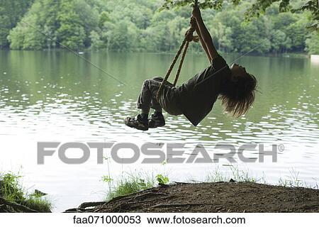 Boy on swing by lake View Large Photo Image Stock Image - Boy on swing by lake. Fotosearch