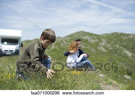 Stock Photograph - Boy playing with grass. Fotosearch