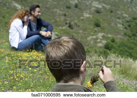 Boy playing with wildflowers, rear view View Large Photo Image Stock Photography - Boy playing with wildflowers, rear view. Fotosearch