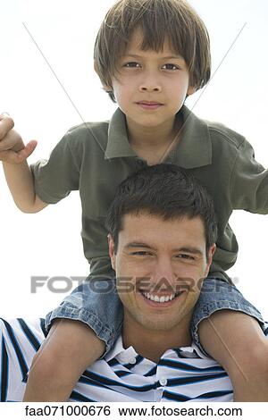 Boy riding on his father's shoulders, portrait View Large Photo Image Stock Photograph - Boy riding on his father's shoulders, portrait. Fotosearch