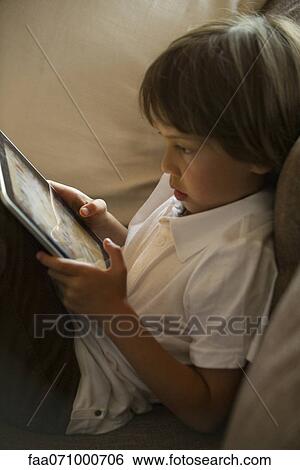 Stock Photograph - Boy using digital tablet. Fotosearch