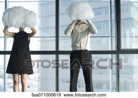 Businessman and businesswoman hiding behind clouds View Large Photo Image Stock Photo - Businessman and businesswoman hiding behind clouds. Fotosearch
