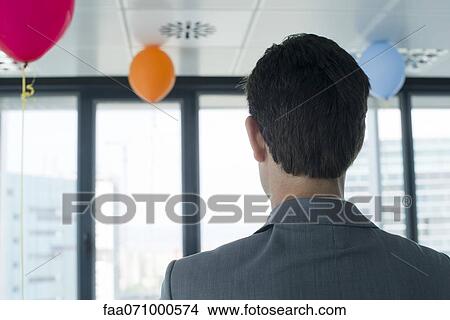 Businessman in room with balloons View Large Photo Image Picture - Businessman in room with balloons. Fotosearch
