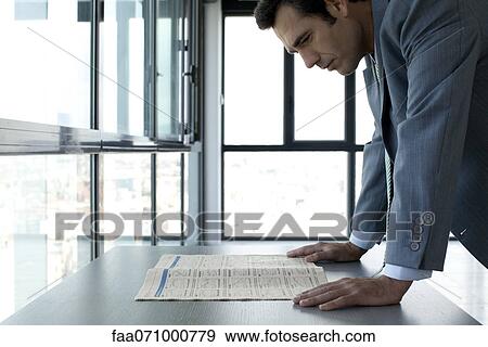 Businessman reading finance section of newspaper View Large Photo Image Stock Photo - Businessman reading finance section of newspaper. Fotosearch