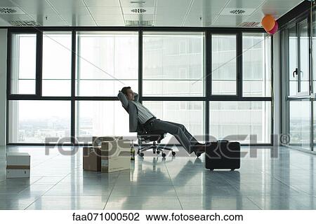 Businessman sitting in empty office with boxes on floor View Large Photo Image Stock Image - Businessman sitting in empty office with boxes on floor. Fotosearch