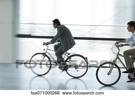 Businessmen riding bicycles indoors, silhouette, blurred motion View Large Photo Image Stock Photo - Businessmen riding bicycles indoors, silhouette, blurred motion. Fotosearch