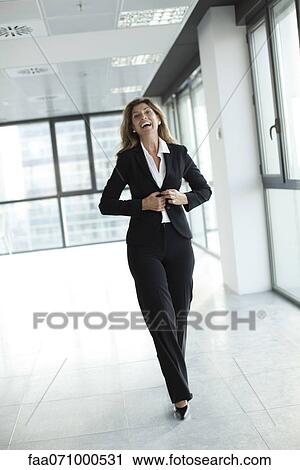 Businesswoman laughing while walk toward camera View Large Photo Image Stock Image - Businesswoman laughing while walk toward camera. Fotosearch