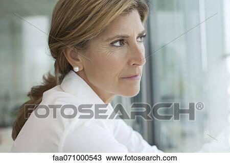 Businesswoman looking out of window View Large Photo Image Stock Image - Businesswoman looking out of window. Fotosearch