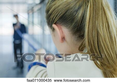 Stock Photography - Businesswoman playing tug-of-war, over the shoulder view, cropped. Fotosearch