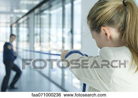 Businesswoman playing tug-of-war, rear view View Large Photo Image Stock Photograph - Businesswoman playing tug-of-war, rear view. Fotosearch