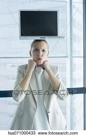 Stock Image - Businesswoman with laptop computer on head. Fotosearch