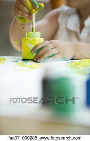 Child dipping paintbrush into jar of paint View Large Photo Image Stock Photo - Child dipping paintbrush into jar of paint. Fotosearch