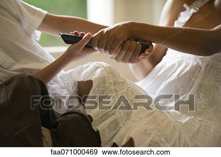 Children fighting over remote control, cropped View Large Photo Image Stock Photo - Children fighting over remote control, cropped. Fotosearch