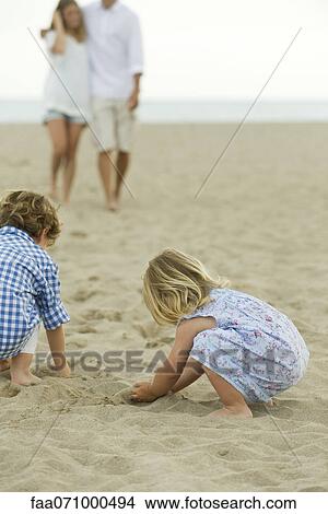 Children playing in sand at the beach View Large Photo Image Picture - Children playing in sand at the beach. Fotosearch