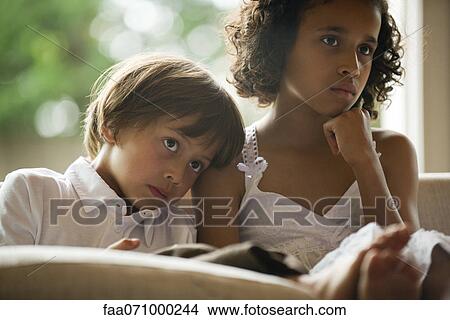 Children watching TV together, boy resting head on sister's shoulder View Large Photo Image Picture - Children watching TV together, boy resting head on sister's shoulder. Fotosearch