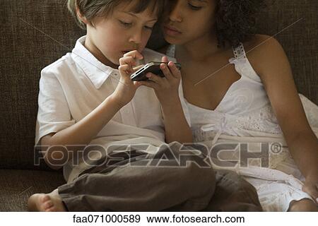 Chldren looking at cell phone View Large Photo Image Stock Photo - Chldren looking at cell phone. Fotosearch