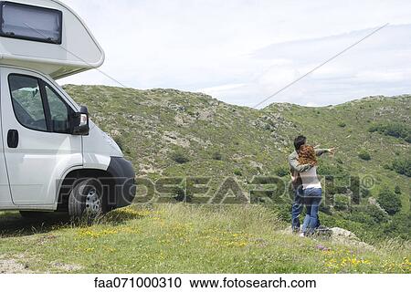 Stock Image - Couple embracing and enjoying scenic view. Fotosearch