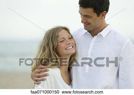Couple embracing at the beach View Large Photo Image Stock Image - Couple embracing at the beach. Fotosearch