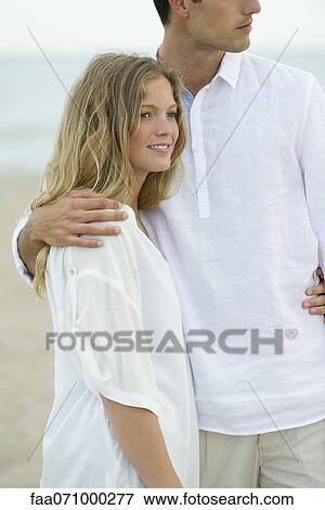 Stock Photo - Couple standing together at the beach. Fotosearch