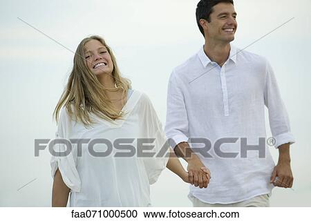 Couple walking hand in hand outdoors View Large Photo Image Stock Image - Couple walking hand in hand outdoors. Fotosearch