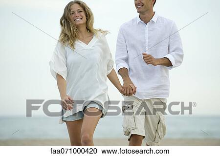 Couple walking together at the beach View Large Photo Image Stock Image - Couple walking together at the beach. Fotosearch